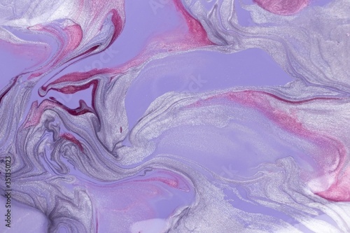 Abstract background of mixed shades of lilac, silver and pink nail polish with a marble pattern. Liquid colorful background paint creative lilac, silver, pink, plum shade with shimmer