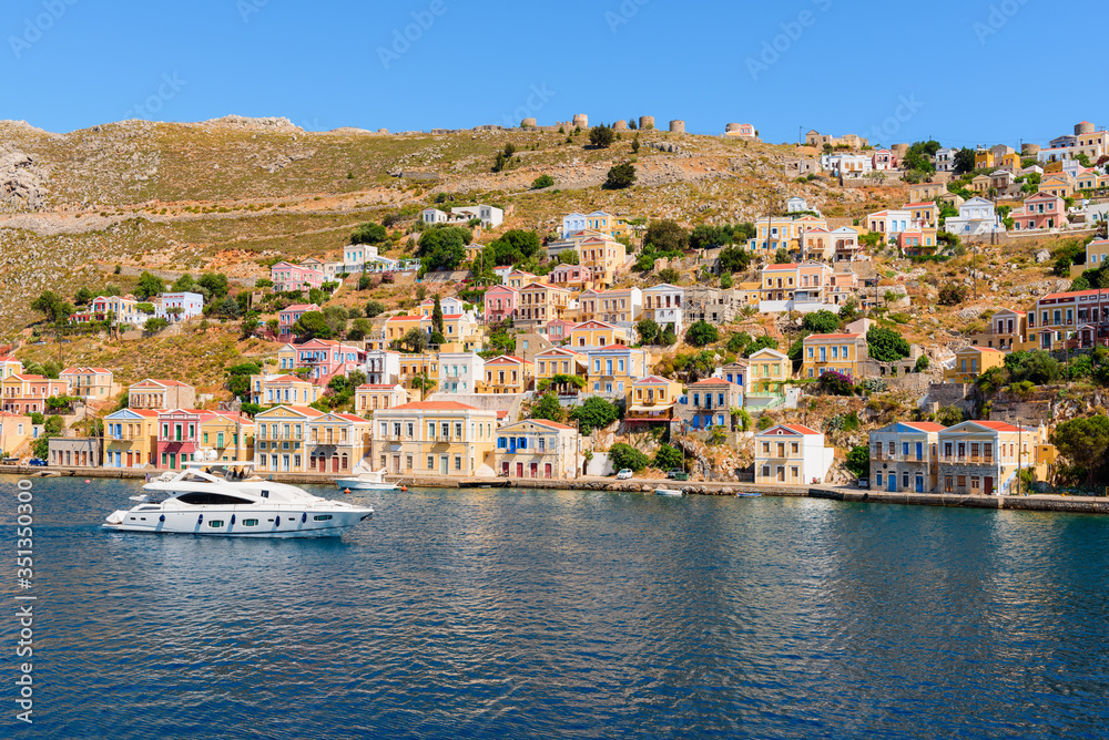 Sea bay and colorful houses on the hillside of the island of Symi. Greece