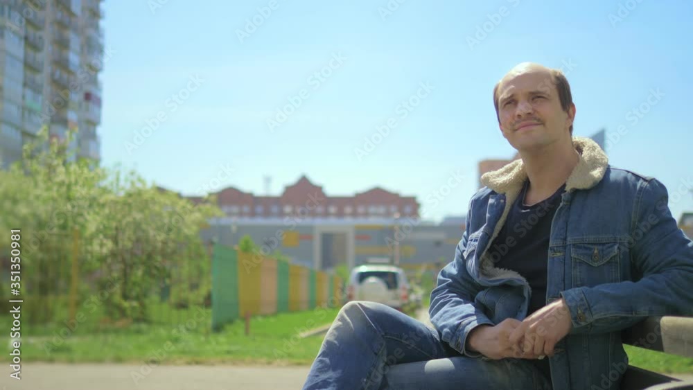 A bald man feeds pigeons while sitting on a bench. humor A bald man feeds pigeons while sitting on a bench. humor