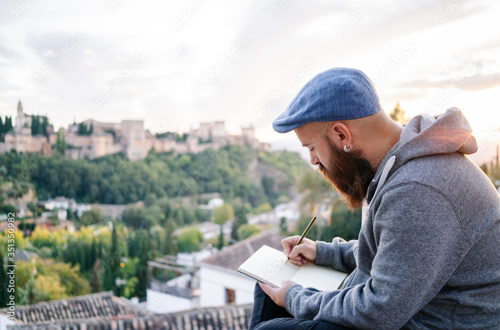 Man at observation point drawing a sketch of the Alhambra, Granada, Spain Man at observation point drawing a sketch of the Alhambra, Granada, Spain