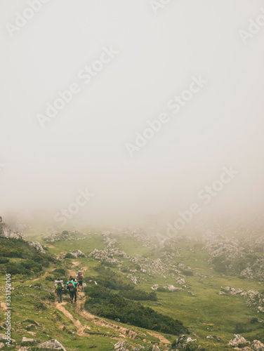 Spain, Cantabria, Group of backpackers hiking in Picos de Europa during foggy weather