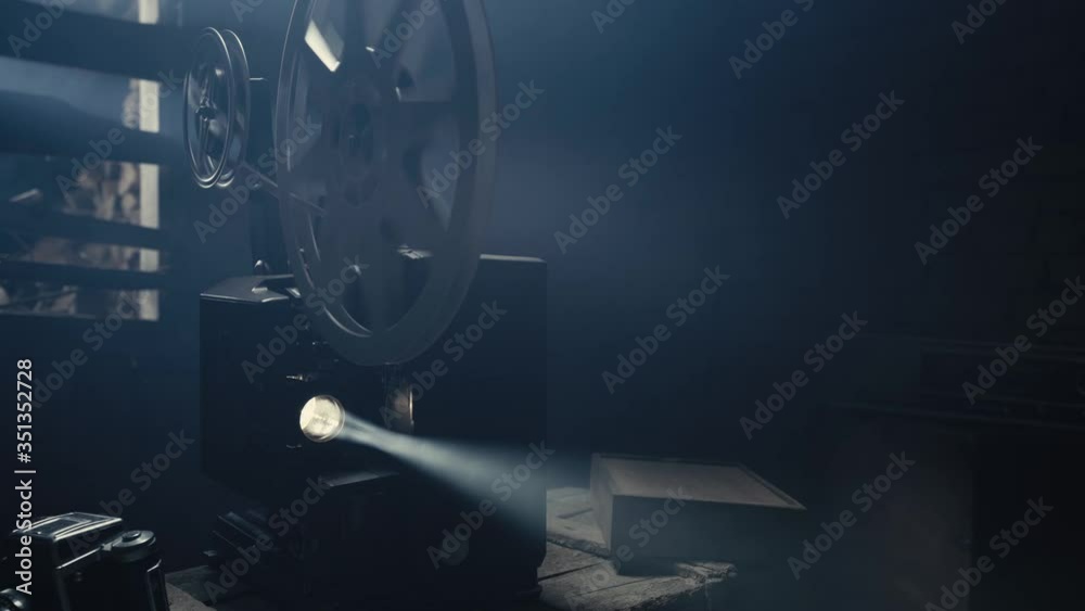An Old Film Projector is a stock video that features beautiful footage of an old 16mm film projector projecting something in a haze.