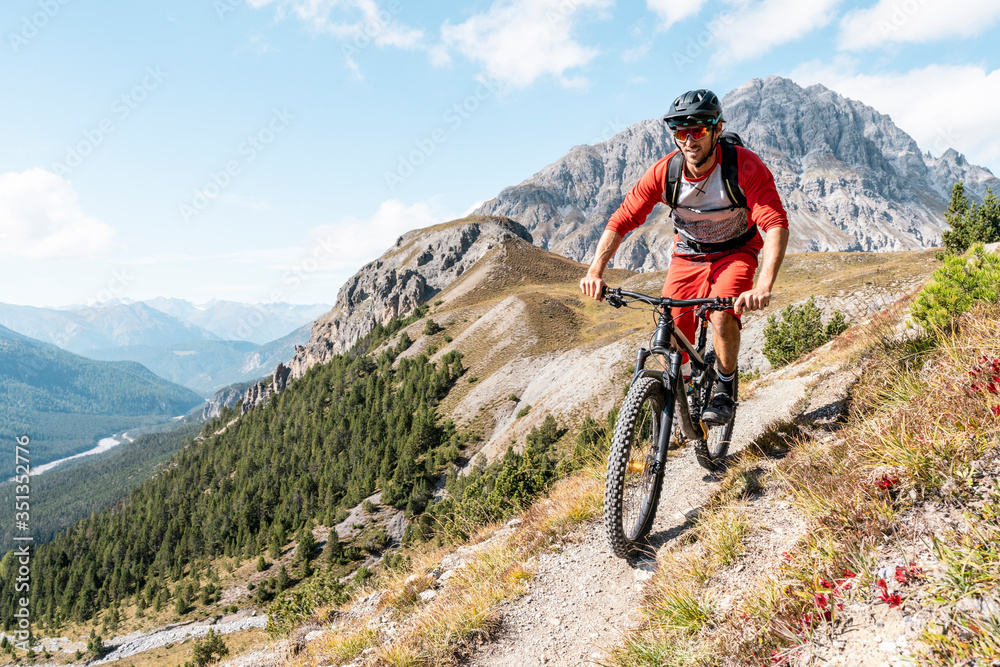 Man riding on mountainbike, Munestertal Valley, Grisons, Switzerland Man riding on mountainbike, Munestertal Valley, Grisons, Switzerland