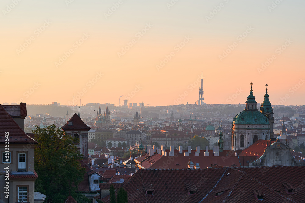 Beautiful morning picture over the Prague old town during early spring sunrise. Picture show rooftops of historic buildings and towers with dome of Saint Nicolas church in Lesser Town under the Castle