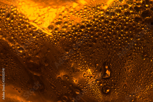 Abstract orange background. Drops of water on the surface are illuminated by the setting sun.