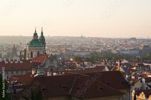 Cityscape picture of Prague, capitol of Czech republic taken from prague castle. Main subject is tower of Saint Nicolas church in Lesser town. Picture is taken in golden hour just after sunrise. © jdmfoto