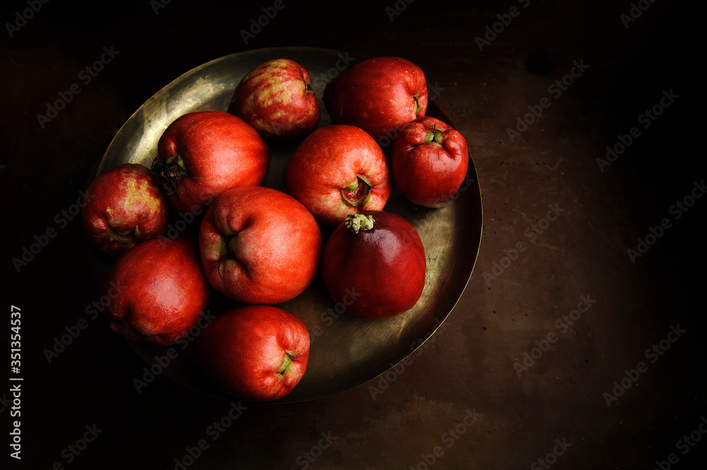 Jambosa fruit, jambo. Selective focus. View from the top. Aged brown background. Text space. Jambosa fruit, jambo. Selective focus. View from the top. Aged brown background. Text space.