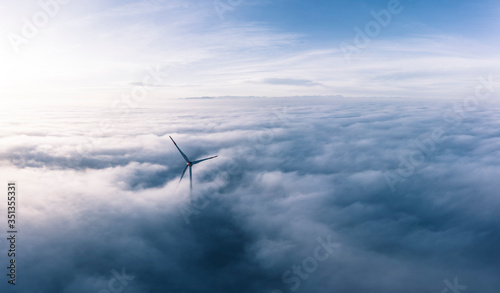 Fototapeta Naklejka Na Ścianę i Meble -  Germany, Aerial view of wind turbine shrouded in clouds at dawn