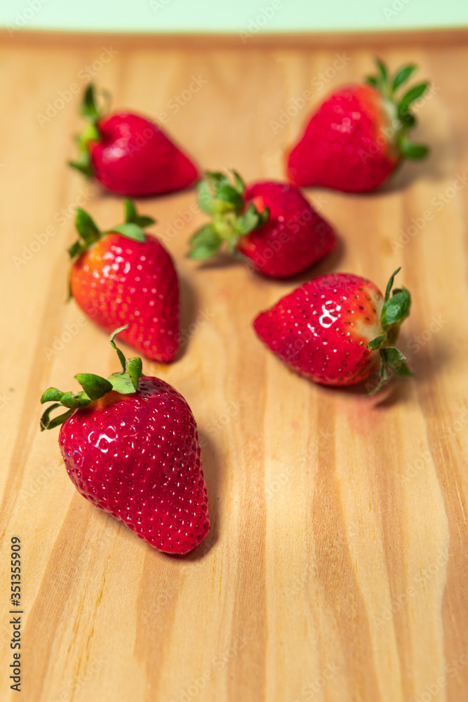 Juicy ripe strawberries. Bunch of berries on a wood table top background. Delicious and healthy strawberry fruit in summer. Vegan diet ingredient.