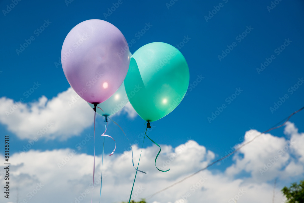 colorful balloons and white clouds in the background