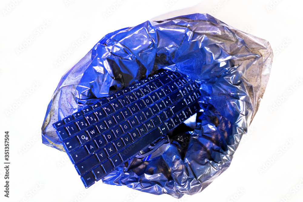 Isolated laptop keyboard is in office trash can, top view. Concept of