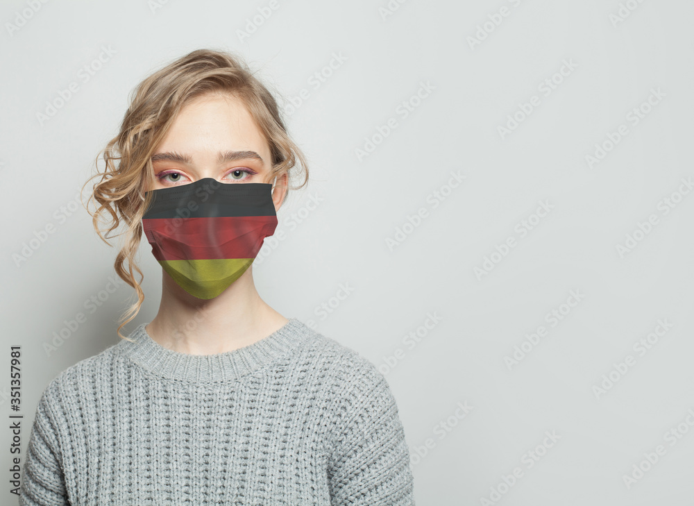 Young woman wearing a face mask with national flag Germany. Flu epidemic and virus protection concept Young woman wearing a face mask with national flag Germany. Flu epidemic and virus protection concept