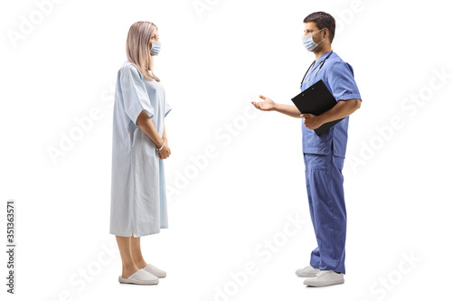 Фemale patient in a hospital gown and a male doctor wearing protective masks