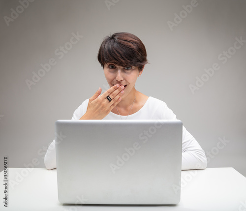 Tactful woman covering her mouth as she giggles