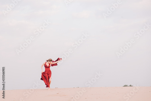 Girl in red dress at sunset in the desert © Denis