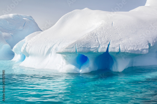 Antarktis, Expeditionsschiff - Glasklares blaues Wasser, das den Schnee blau färbt photo