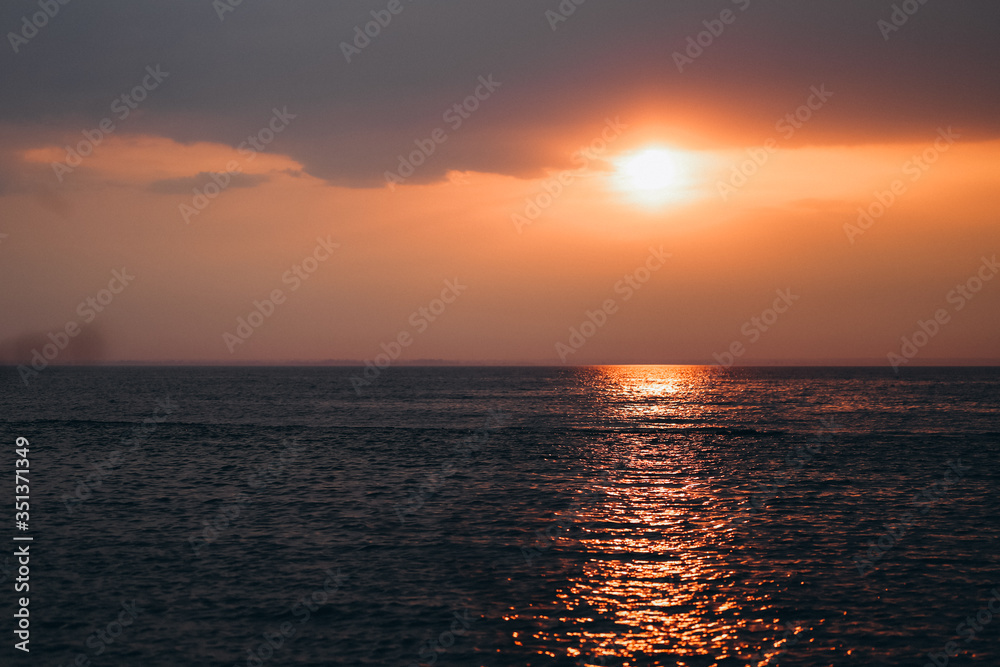 Beautiful orange sunset or sunrise near seaside ocean dark colors Beautiful orange sunset or sunrise near seaside ocean dark colors