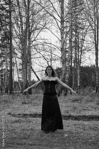 a girl in a black dress in an old forest