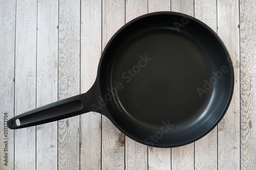 Empty pan on a kitchen table.Empty pan on a kitchen table on wooden culinary background. Top view.