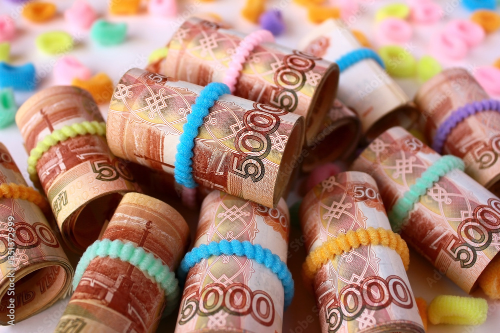 Fototapeta premium Russian money 5000 five thousand rubles twisted into a tube and secured with an elastic band. A lot of money.