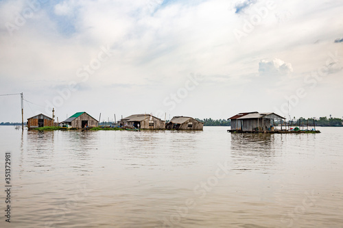 Vietnam, Cần Thơ, Bình Thủy, Zu Besuch bei den Fischzüchtern von fliegenden Fischen auf der Insel Con Son (Cồn Sơn, Bùi Hữu Nghĩa,) in der Nähe von Cần Thơ der größte Stadt im Mekong-Delta und gleichzeitig die Hauptstadt des Mekong Delta. Mit dem Boot geht es über einen Seitenarm des Mekong auf die Insel. Schwimmende Häuser auf dem Wasser. Wohnungen der Fischer., Fischerhäuser auf dem Fluss photo