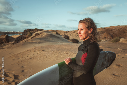 Spanien, Kanaren, La Oliva, Auf der Insel Fuerteventura. Eine Surferin am Strand von Punta Mallorquin ca. 3 km südlich von El Cotillo entfernt