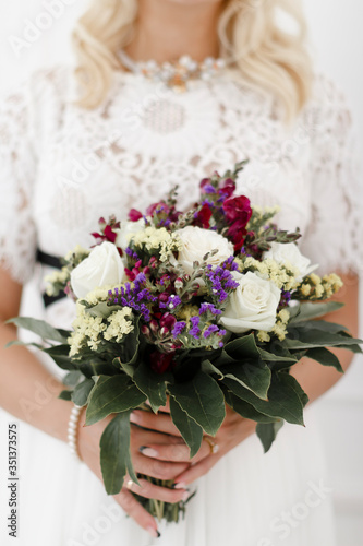 Wedding bouquet in bride's hands. Selective focus. White background.