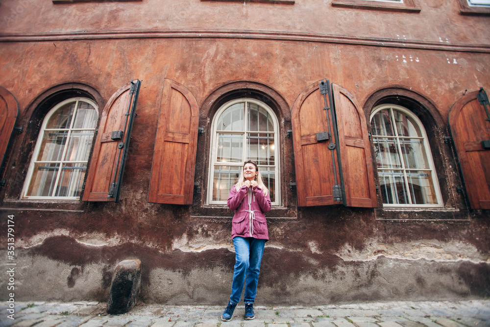 girl near large wooden windows with shutters