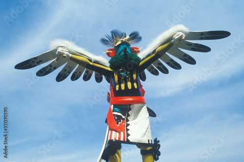 Hopi Kachina doll with outstretched winged arms against blue sky photo