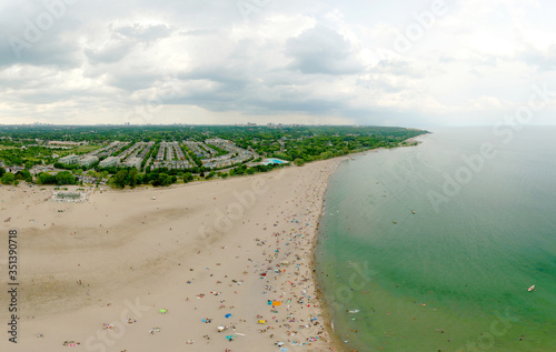 Toronto Woodbine Beach and sandy beach with people swimming, aerial view, Ontario, Canada, rainy cloudy greenery coast with boats at summer. Many residential houses. Popular tourist location photo