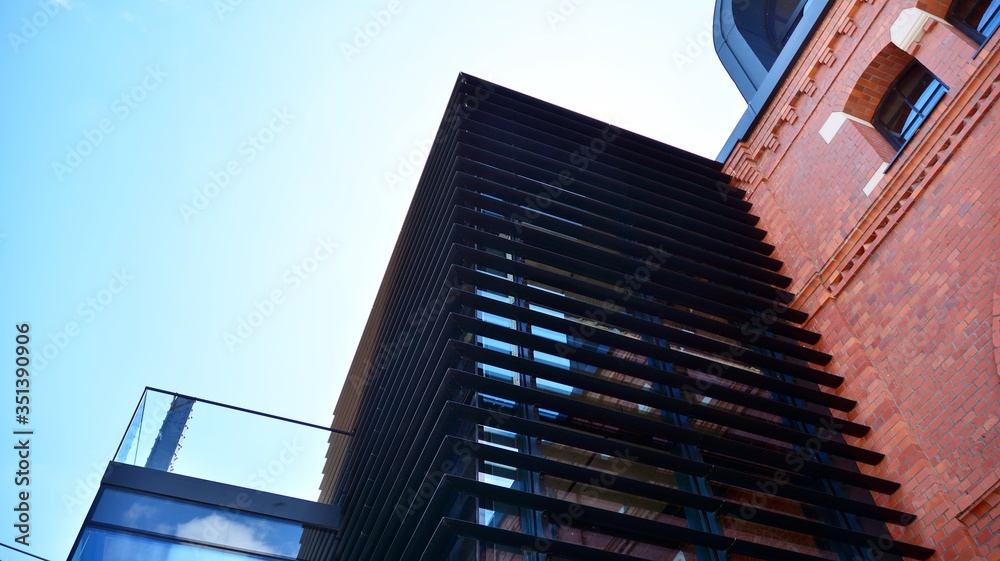 Obraz premium Structural glass wall reflecting blue sky. Abstract modern architecture fragment. View of a modern glass skyscraper, modern office building. Modern office facade fragment with blue glass.