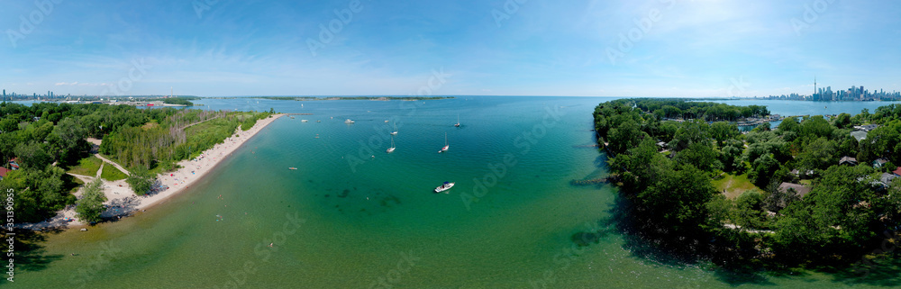 Toronto Central Islands and Ward's Island Park beach, Ontario, Canada, aerial view from top at sunny greenery and sandy coast with boats, people swimming at summer. Popular tourist location.