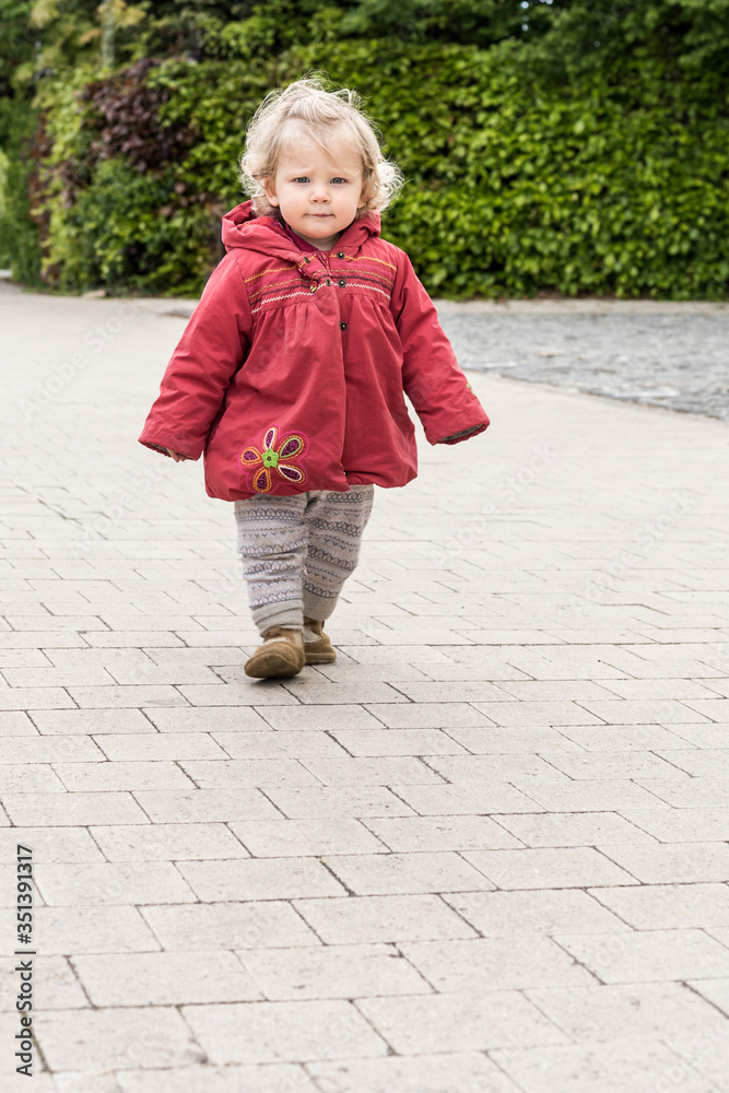 petite fille en manteau rouge marche dans la rue petite fille en manteau rouge marche dans la rue