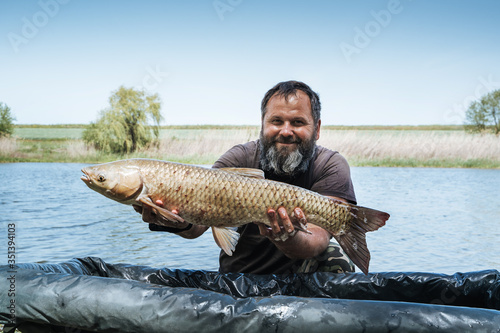 a fisherman in the water holds a large fish caught