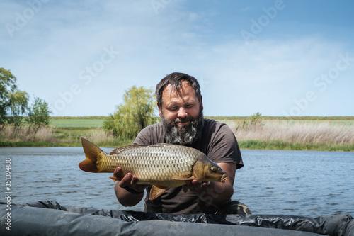 a fisherman in the water holds a large fish caught