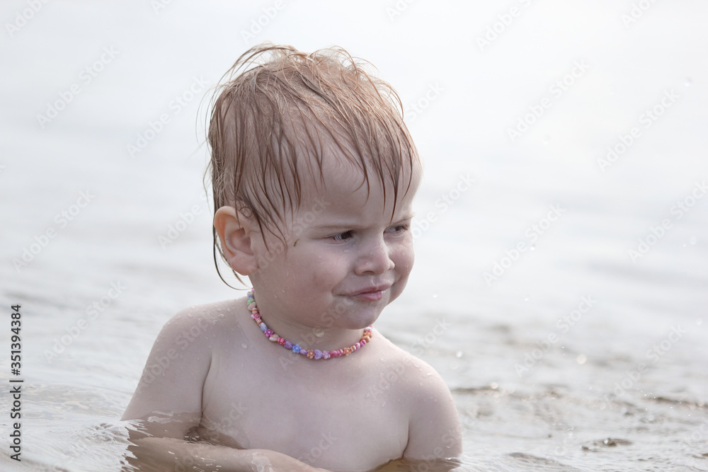 little independent girl sitting in the water on the lake little independent girl sitting in the water on the lake