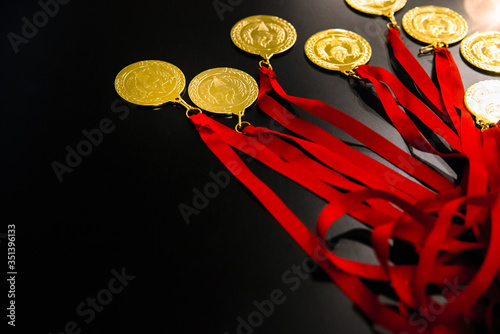 Many gold medals on a table for the victors of their challenges and inspiring goals.