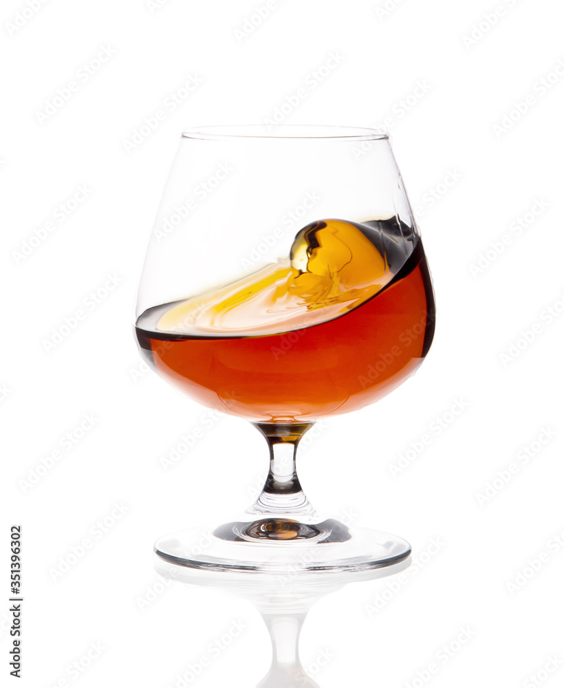 Glass glass with whiskey on a white highlighted background Glass glass with whiskey on a white highlighted background