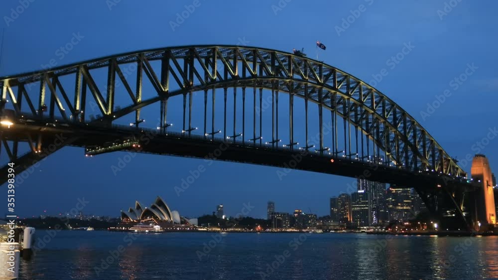 Dark zoom in to Circular Quay waterfront besides the Sydney Harbour bridge at sunset with bright illumination – Australian landmarks.
Dark zoom in to Circular Quay waterfront besides the Sydney Harbour bridge at sunset with bright illumination – Australian landmarks.