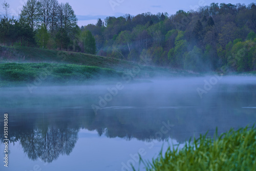 Fototapeta Naklejka Na Ścianę i Meble -  On a misty spring evening landscape. Fog over the river and forest. The beauty in nature.