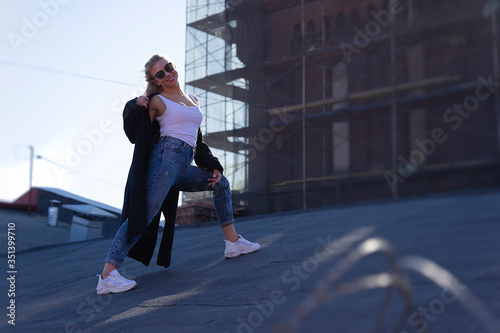 European girl with blond hair walking on the roof. Joyful emotions