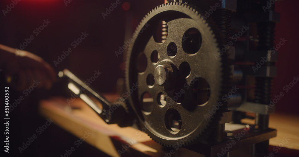 Machine with a big cogwheel on a dark red background