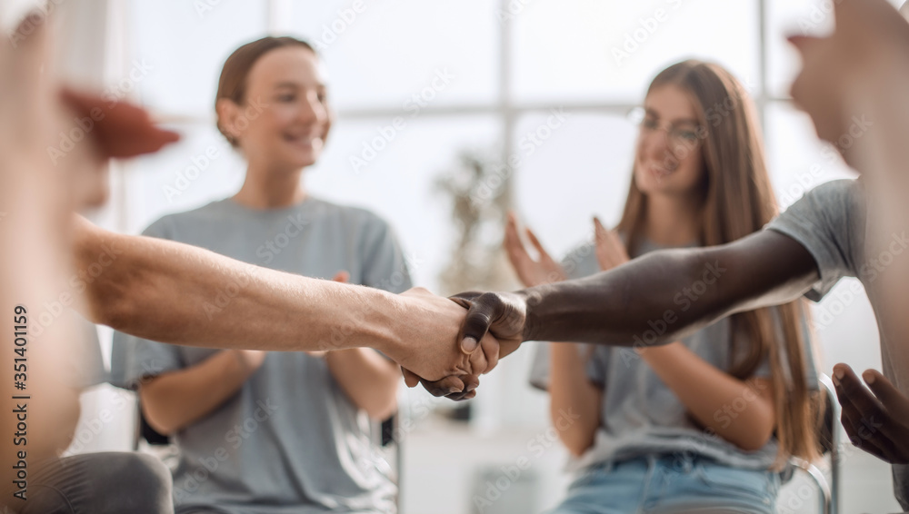 close up. smiling guy shaking hands with his friend close up. smiling guy shaking hands with his friend