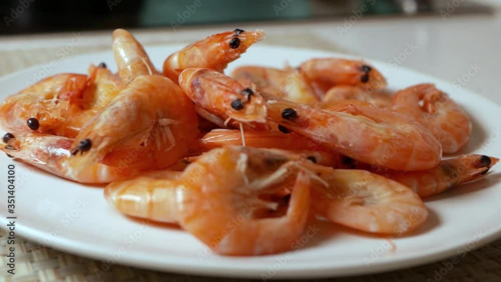 Hot boiled fresh shrimps in a white plate, close-up Hot boiled fresh shrimps in a white plate, close-up