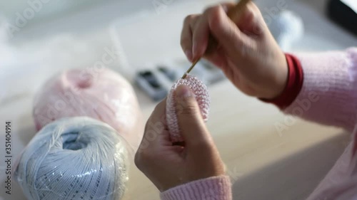 Câmera lenta de uma pessoa fazendo crochê, para passar o tempo durante a quarentena contra o corona vírus. Amigurumi. photo