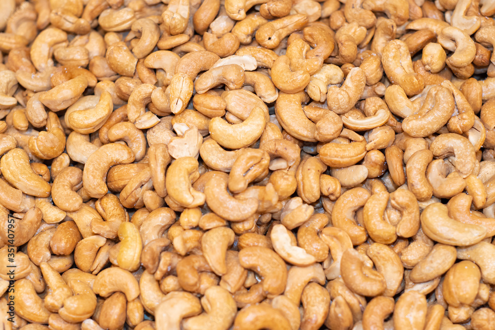 Tasty cashew nuts fried as background, top view
