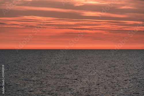 Red colored cloudy sky after sunset over the sea  nature background.