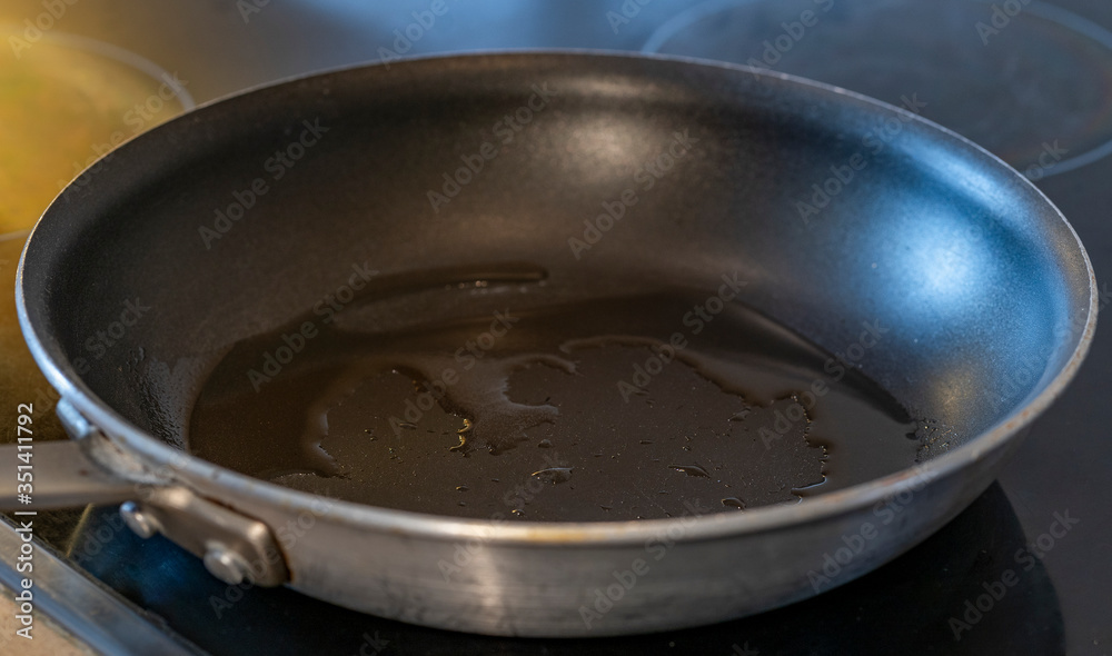 Close up of cooking pan with oil in modern stove Close up of cooking pan with oil in modern stove