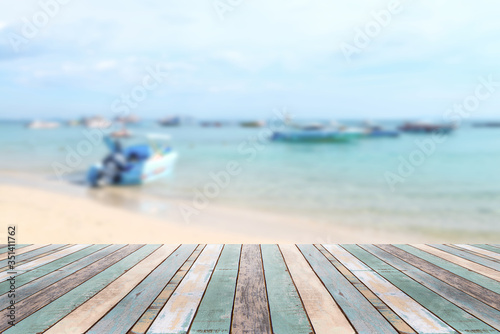 Wood table top with blurred boat at the beach