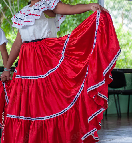 Bright red wide skirt swirling as a young girl does a traditional Costa Rican dance.